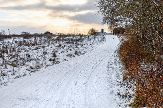 Snow covered rural road under winter sky