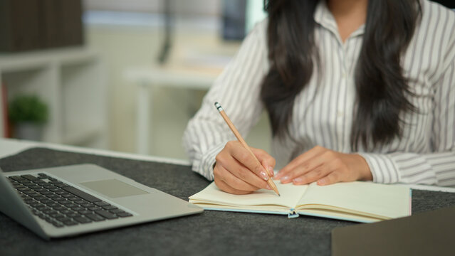 Closeup businesswoman hand working with writing on notebook