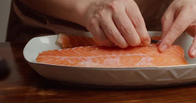 Preparing the salmon: Remove the bones from the fillet with a piercer. Season the fresh salmon fillet on a wooden table with sea salt and add refined sugar.