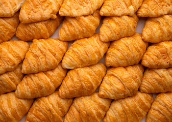Top view of many fresh golden brown croissants pattern, Delicious French pastry for breakfast