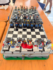 Obraz premium LEGO chessboard featuring medieval knights, kings, and fantasy figures as chess pieces on a checkered baseplate: 01.09.2024-Trieste, Italy