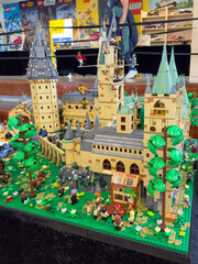 Obraz premium LEGO display of Hogwarts Castle from the Harry Potter universe, featuring towers, a greenhouse, and numerous wizard minifigures on a large green baseplate: 06.10.2024-Ljubljana, Slovenia