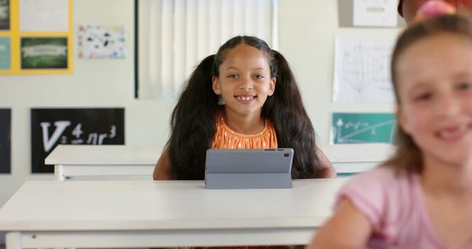 Camera refining focus, classmates in classroom watching youth female student learning with tablet