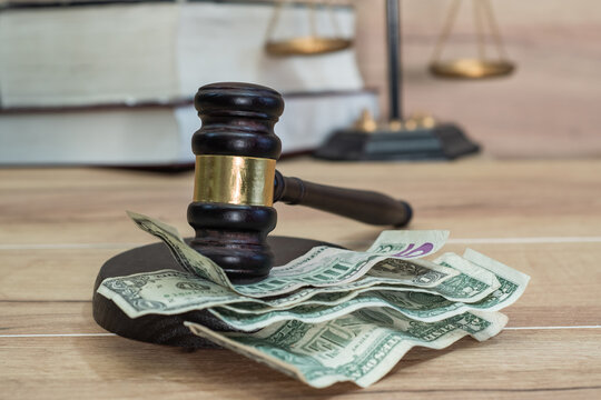 Financial bribery of the American justice system. Corruption in the US legal system. Judge's gavel and cash dollars in a judge's office. Law reform in favor of business interests