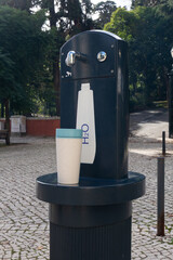 Reusable travel cup on public drinking water fountain