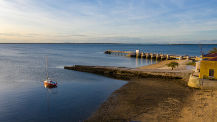 Aerial view of the shoreline embraces the soft blues of the water meeting the pier under the vast sky, Ilha de Mocambique, Nampula, Mozambique.