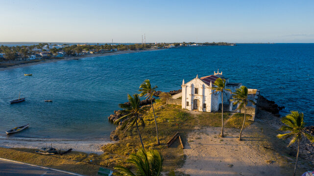 Aerial view of the Chapel of Nossa Senhora de Baluarte stands majestically against the azure sea, a beacon of history and faith, Ilha de Mocambique, Nampula, Mozambique.