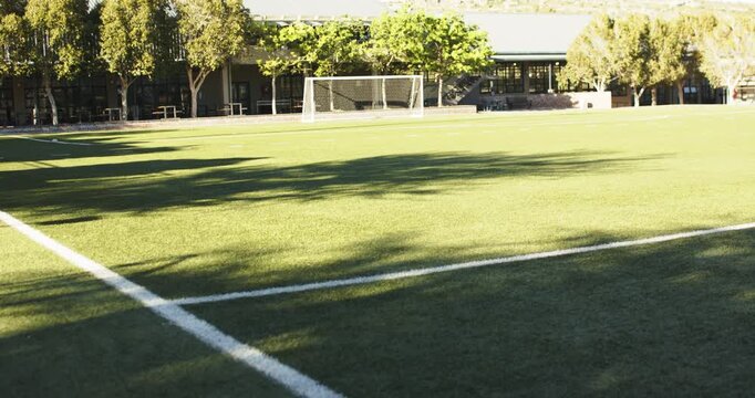 Camera is pulling back and tilting up, revealing white soccer goal and pitch for establishing shot