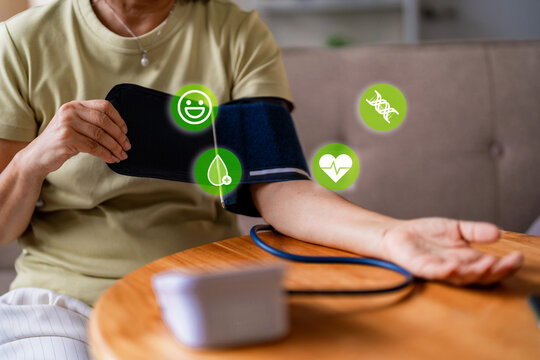 Senior woman check blood pressure use modern tonometer at home for wellness preventive care with health icons healthcare medical technology