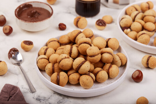 Italian cookies Baci di Dama. Small sandwich cookies with hazelnut or almond flour and chocolate cream filling. Delicious homemade dessert.