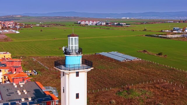 Moving around the top of the Aheloy lighthouse. View on the bright red-roofed cityscape of the Bulgarian city at backdrop.