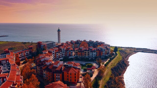 Beautiful Marina Cape hotel complex with the lighthouse at backdrop. Shore of the Black Sea in Aheloy, Bulgaria at sunset.
