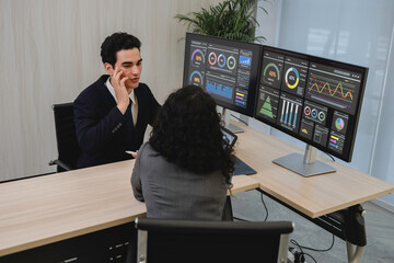 Business professionals analyzing data and discussing financial reports with digital dashboards and graphs in a modern office setting, focusing on strategy and performance.