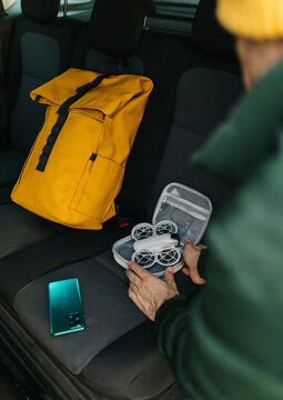 Man preparing drone in vehicle interior