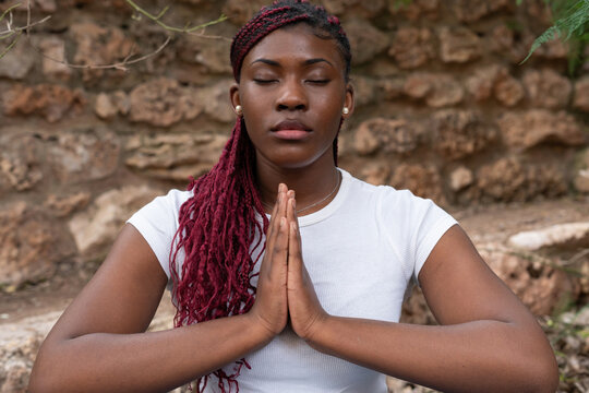 Young woman practicing yoga and meditating outdoors in nature