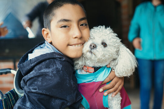 Happy disabled child hugging his dog at home