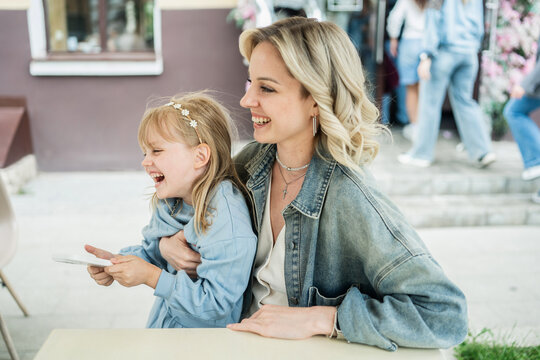 Mom and daughter enjoying time at a street cafe