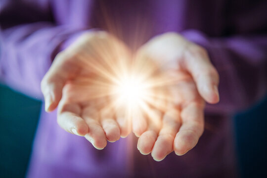 Woman Holding Glowing Light in Open Hands as Give to Gain Symbol of Empowerment and Sharing