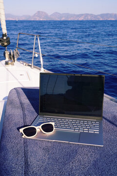 Remote work on a yacht with a laptop and sunglasses