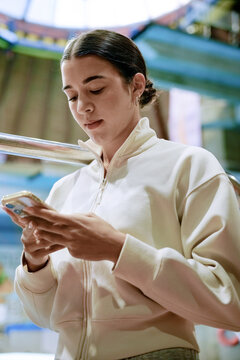 Focused sportwoman checks fitness app on smartphone