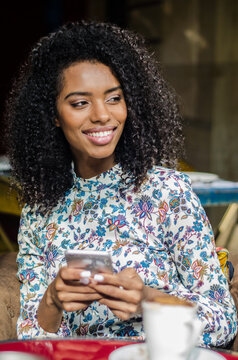 Woman enjoying a relaxed lifestyle with phone and coffee