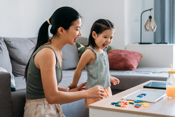 Mother and daughter enjoying educational playtime at table