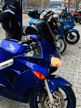 Blue Honda VFR 800 motorcycle parade with riders and spectators in an outdoor show