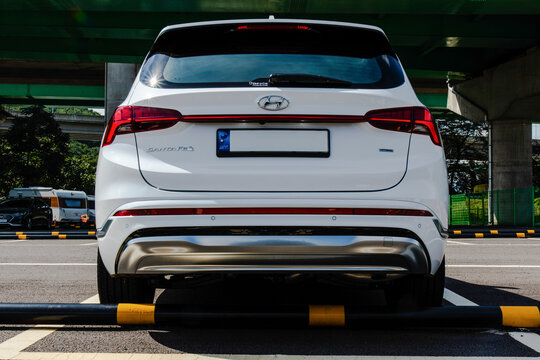 September 26, 2021, Seoul, South Korea - Rear view of a white Hyundai Santa Fe SUV parked in a lot under a bridge.