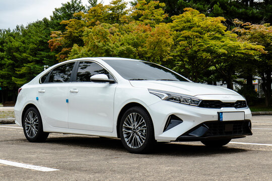September 19, 2021, Seoul, South Korea - White Kia K3 sedan parked outdoors with trees