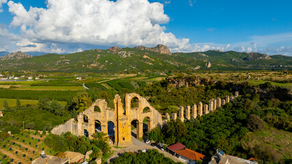 Obraz premium Aspendos Aerial panoramic view of the Roman aqueduct that served the ancient city. Aqueducts in the land of Aspendos in Antalya. Aerial panoramic view of the Roman aqueduct that served the area of Ma