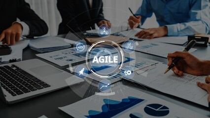This image showcases a collaborative business environment emphasizing agile project management with team members analyzing data and charts to drive innovation and growth. Raster