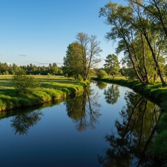 Clear blue sky reflecting perfectly on the winding river flowing through a natural peaceful landscape during a bright sunny day ,vast ,sky ,smooth