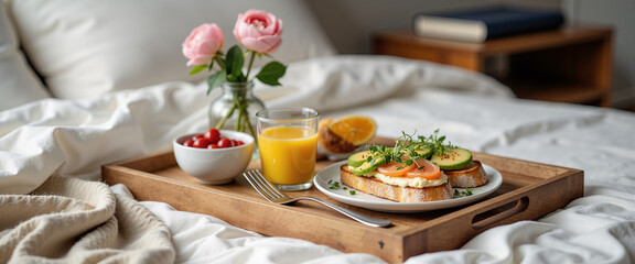 Fancy breakfast in tray on bed with flowers and juice  