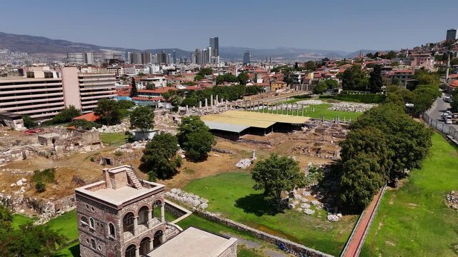 Aerial view of ancient agora ruins in Izmir, Turkey. Archaeological site with columns and excavations surrounded by modern city buildings, urban landscape, history and cultural heritage.