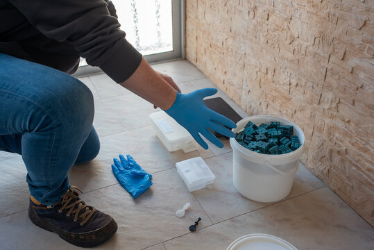 Exterminator reaching for rodent bait station and supplies during service