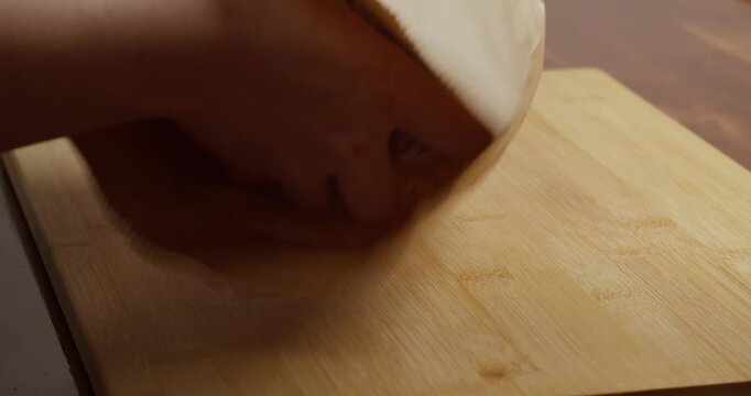 Close up woman hand's taking black bread out of paper bag in kitchen