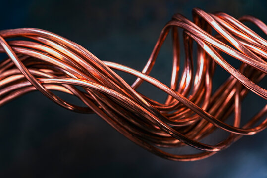 Close-up low angle view of twisted copper wire as a non-ferrous raw material for the electrical power industry, symbolizing conductivity and the flow of energy and data in an industrial environment.