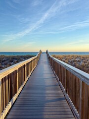 Fototapeta premium A wooden boardwalk to the Florida beach at sunset over the sand dunes.