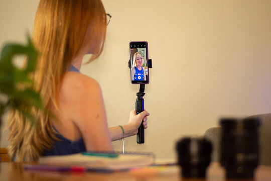 mulher gravando v&iacute;deo com celular, influenciadora filmando conte&uacute;do para redes sociais