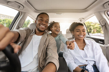 Auto Purchase. Joyful Black Family Having Road Trip Sitting In New Car Enjoying Summer Weekend...