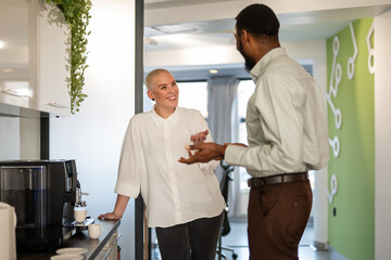 Fototapeta premium Colleagues having coffee break conversation in office kitchen