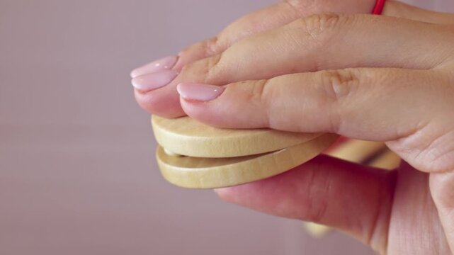 Woman holding in hands and playing wooden Castanets musical instrument close up