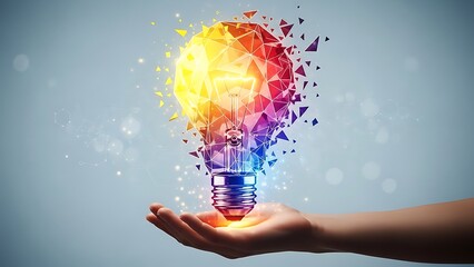 Hand holding glowing rainbow lightbulb with geometric shapes exploding