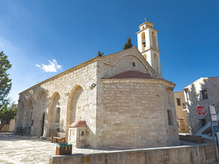 Panagia Evangelistria church in Kathikas village, Cyprus, featuring traditional stone architecture and a bell tower under a clear sky