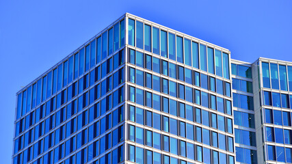 A modern tall building made of steel and glass, housing offices and financial institutions. Glass...