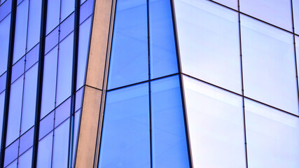 A modern tall building made of steel and glass, housing offices and financial institutions. Glass...