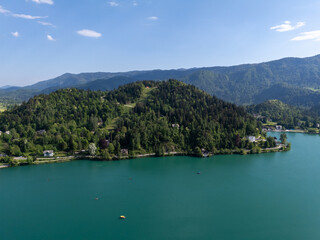 Aerial view of Bled Castle overlooking Lake Bled, Slovenia. Medieval fortress on a cliff captured by drone, surrounded by alpine landscape and clear blue water. Famous European travel destination and 