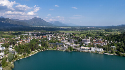 Aerial view of Bled Castle overlooking Lake Bled, Slovenia. Medieval fortress on a cliff captured by drone, surrounded by alpine landscape and clear blue water. Famous European travel destination and 
