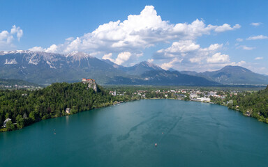 Aerial view of Bled Castle overlooking Lake Bled, Slovenia. Medieval fortress on a cliff captured by drone, surrounded by alpine landscape and clear blue water. Famous European travel destination and 