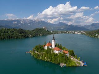 Aerial drone view of Bled Island with the Church of the Assumption in the middle of Lake Bled, Slovenia. The iconic island church is surrounded by turquoise alpine waters and forested mountains. Famou